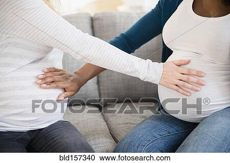 Pregnant women feeling stomachs of each other View Large Photo Image Stock Image - Pregnant women feeling stomachs of each other. Fotosearch