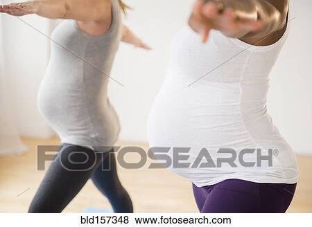 Pregnant women practicing yoga with arms outstretched View Large Photo Image Stock Photo - Pregnant women practicing yoga with arms outstretched. Fotosearch