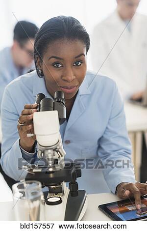 Scientist using microscope and digital tablet in research laboratory View Large Photo Image Stock Photo - Scientist using microscope and digital tablet in research laboratory. Fotosearch