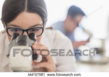 Stock Image - Scientist using microscope in research laboratory. Fotosearch