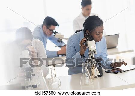 Scientists using microscopes and digital tablet in research laboratory View Large Photo Image Stock Image - Scientists using microscopes and digital tablet in research laboratory. Fotosearch
