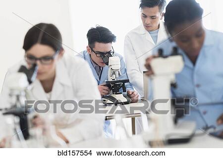 Picture - Scientists using microscopes in research laboratory. Fotosearch