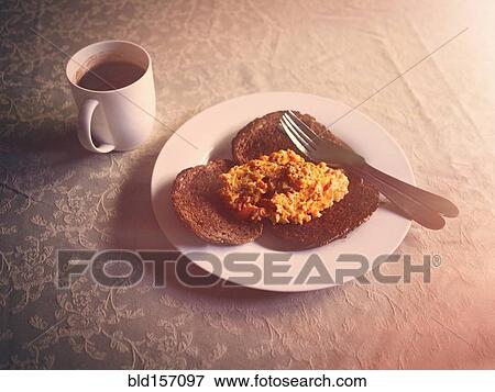 Stock Photo - Scrambled egg and toast breakfast with coffee. Fotosearch