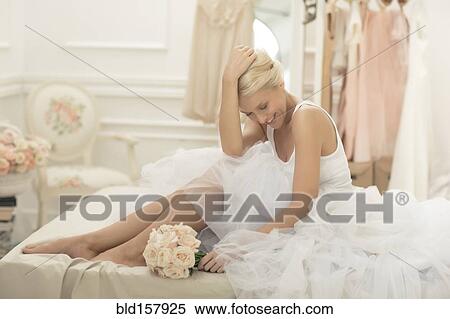 Smiling bride sitting with bouquet on bed View Large Photo Image Stock Photography - Smiling bride sitting with bouquet on bed. Fotosearch