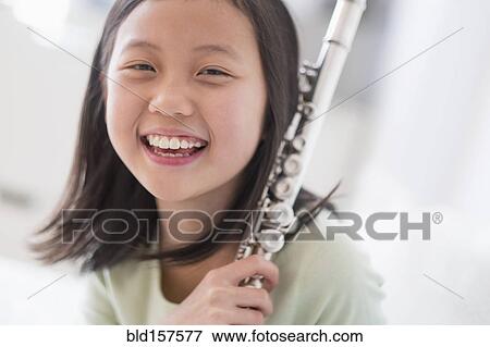 Stock Photo - Smiling Chinese girl holding flute. Fotosearch
