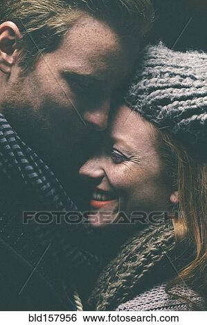 Smiling couple wearing warm clothing hugging View Large Photo Image Stock Photograph - Smiling couple wearing warm clothing hugging. Fotosearch