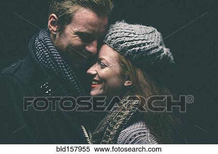 Smiling couple wearing warm clothing hugging View Large Photo Image Stock Photography - Smiling couple wearing warm clothing hugging. Fotosearch
