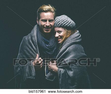 Smiling couple wrapped in blanket View Large Photo Image Stock Image - Smiling couple wrapped in blanket. Fotosearch