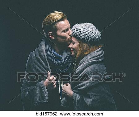 Smiling couple wrapped in blanket kissing View Large Photo Image Stock Image - Smiling couple wrapped in blanket kissing. Fotosearch
