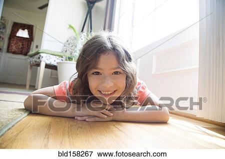 Smiling Hispanic girl laying on floor View Large Photo Image Stock Photo - Smiling Hispanic girl laying on floor. Fotosearch