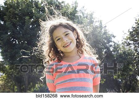 Smiling Hispanic girl standing outdoors View Large Photo Image Stock Photo - Smiling Hispanic girl standing outdoors. Fotosearch