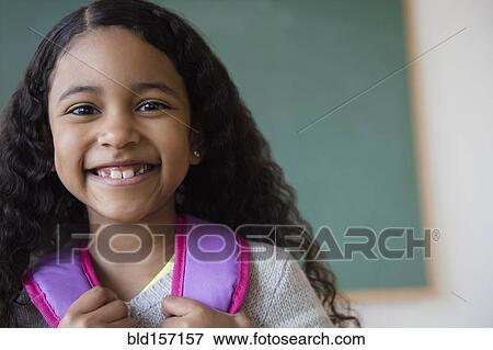 Smiling mixed race student wearing backpack in classroom View Large Photo Image Stock Photo - Smiling mixed race student wearing backpack in classroom. Fotosearch