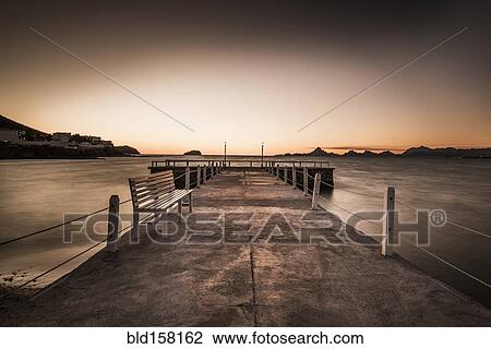 Stone walkway and ocean waves under sunset sky View Large Photo Image Stock Image - Stone walkway and ocean waves under sunset sky. Fotosearch