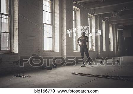 Stock Photo - Virtual words circling Black athlete checking fitness tracker. Fotosearch