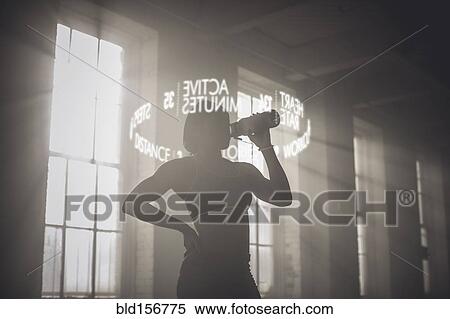 Stock Photography - Virtual words circling Black athlete drinking from bottle. Fotosearch