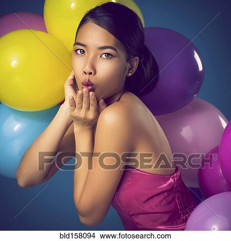 Woman blowing kiss with party balloons View Large Photo Image Picture - Woman blowing kiss with party balloons. Fotosearch