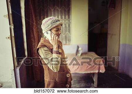 Stock Image - Woman in knit hat talking on cell phone. Fotosearch