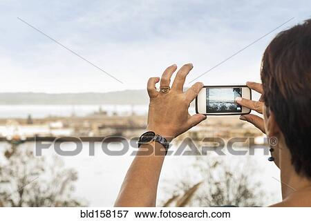 Woman taking cell phone photograph of beach View Large Photo Image Stock Photo - Woman taking cell phone photograph of beach. Fotosearch