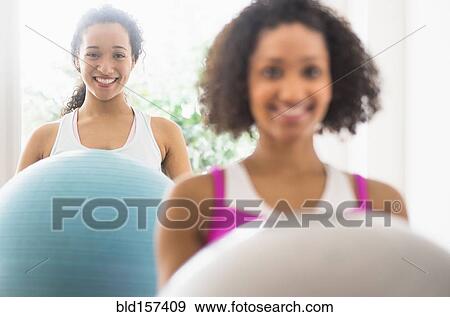 Women working out with fitness balls in exercise class View Large Photo Image Stock Photo - Women working out with fitness balls in exercise class. Fotosearch