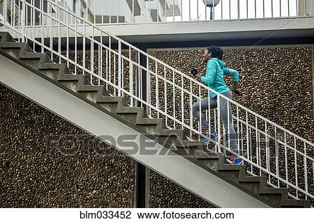 Stock Image - Black runner climbing staircase. Fotosearch