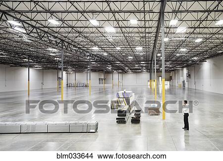 Caucasian businessman standing in empty warehouse View Large Photo Image Picture - Caucasian businessman standing in empty warehouse. Fotosearch
