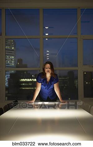 Caucasian businesswoman leaning over conference table at night View Large Photo Image Stock Image - Caucasian businesswoman leaning over conference table at night. Fotosearch