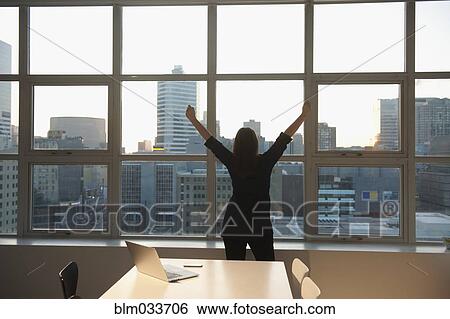 Caucasian businesswoman stretching at office window View Large Photo Image Stock Photograph - Caucasian businesswoman stretching at office window. Fotosearch