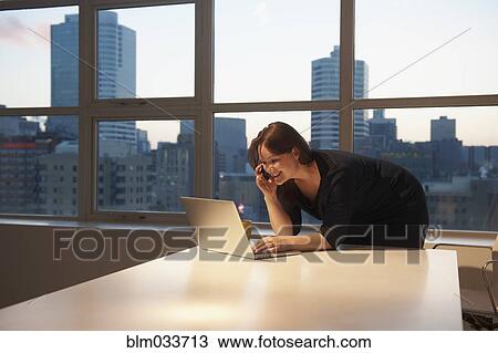Stock Image - Caucasian businesswoman using laptop in office. Fotosearch