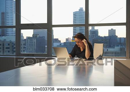 Stock Photo - Caucasian businesswoman using laptop in office. Fotosearch