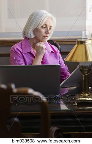 Stock Photo - Caucasian businesswoman working at office desk. Fotosearch