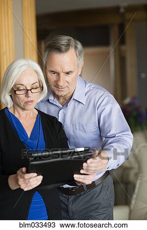 Stock Image - Caucasian couple using digital tablet. Fotosearch