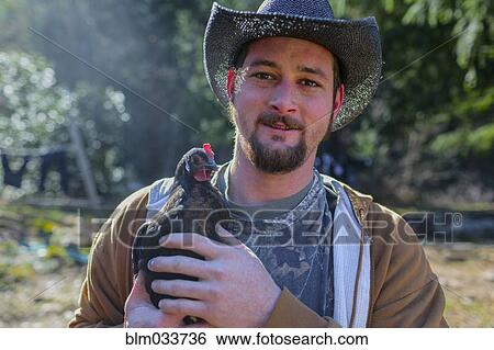 Caucasian farmer holding chicken View Large Photo Image Stock Photograph - Caucasian farmer holding chicken. Fotosearch