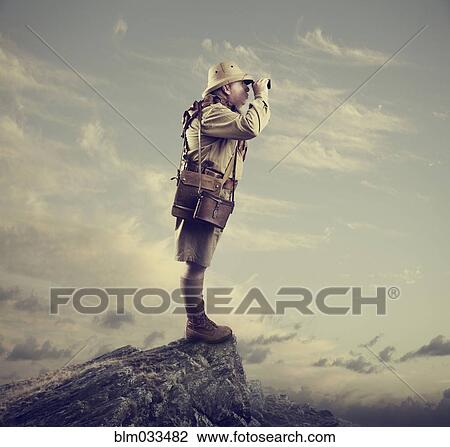 Stock Image - Caucasian hunter using binoculars on mountaintop. Fotosearch