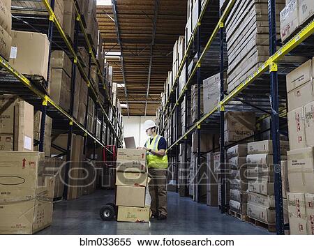 Caucasian worker using laptop in warehouse View Large Photo Image Stock Photography - Caucasian worker using laptop in warehouse. Fotosearch