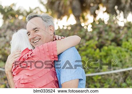 Picture - Close up of older Caucasian couple hugging. Fotosearch