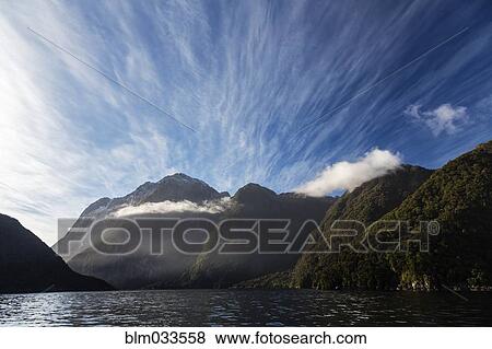 Stock Photo - Forested mountains over remote river, Te Anau, Southland, New Zealand. Fotosearch