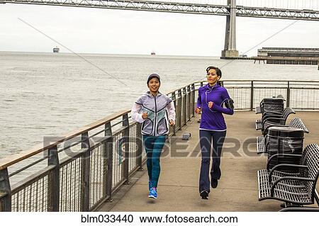 High angle view of women running at waterfront View Large Photo Image Stock Image - High angle view of women running at waterfront. Fotosearch