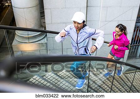 High angle view of women running on staircase View Large Photo Image Stock Image - High angle view of women running on staircase. Fotosearch