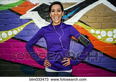 Hispanic runner smiling near graffiti wall View Large Photo Image Stock Image - Hispanic runner smiling near graffiti wall. Fotosearch