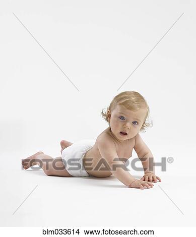 Picture - Mixed race baby girl crawling on floor. Fotosearch