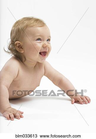 Stock Image - Mixed race baby girl crawling on floor. Fotosearch