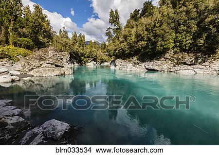 Picture - Rocks and trees around still remote lake. Fotosearch