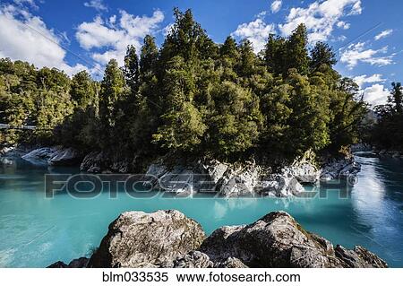 Stock Photography - Rocks and trees around still remote lake. Fotosearch