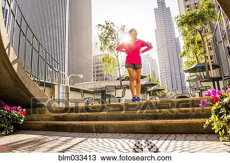 Runner standing on city steps near high rise buildings View Large Photo Image Stock Image - Runner standing on city steps near high rise buildings. Fotosearch