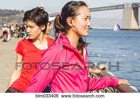 Stock Photograph - Runner stretching at waterfront, San Francisco, California, United States. Fotosearch