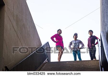 Stock Photography - Runners standing at top of urban staircase. Fotosearch