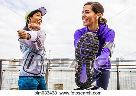 Stock Photo - Runners stretching at waterfront, San Francisco, California, United States. Fotosearch