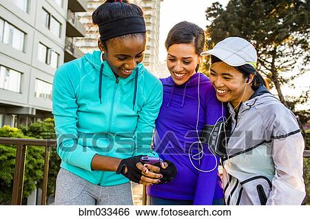 Stock Photograph - Runners using cell phone in city. Fotosearch