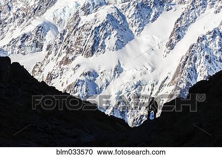 Stock Image - Silhouette of hiker on snowy mountain slope. Fotosearch