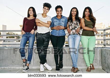 Smiling women standing on urban rooftop View Large Photo Image Stock Image - Smiling women standing on urban rooftop. Fotosearch